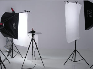 Close-up view of a large rectangular softbox casting soft, diffused light onto a reflective product during a studio photography session